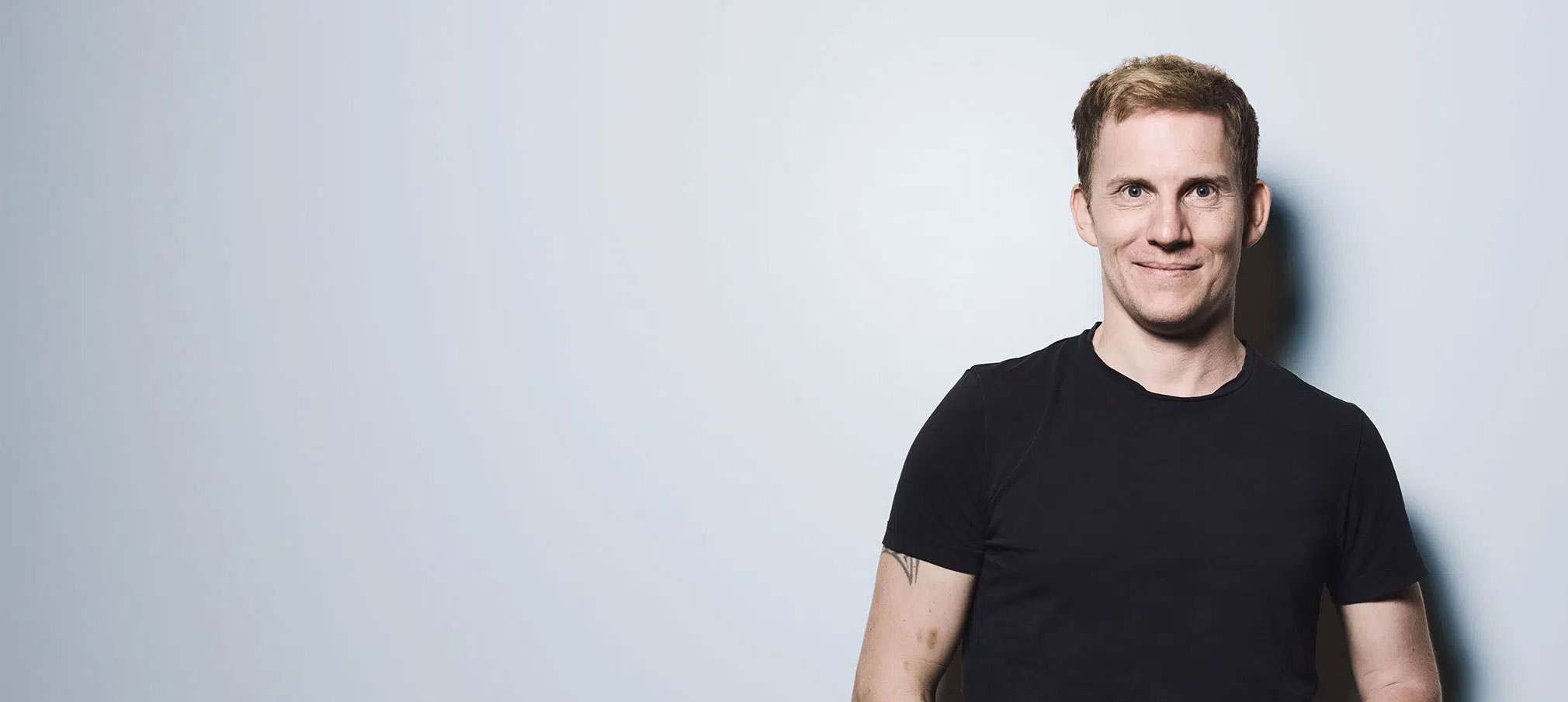 Doente com blusa pontilhada sorri para a câmara