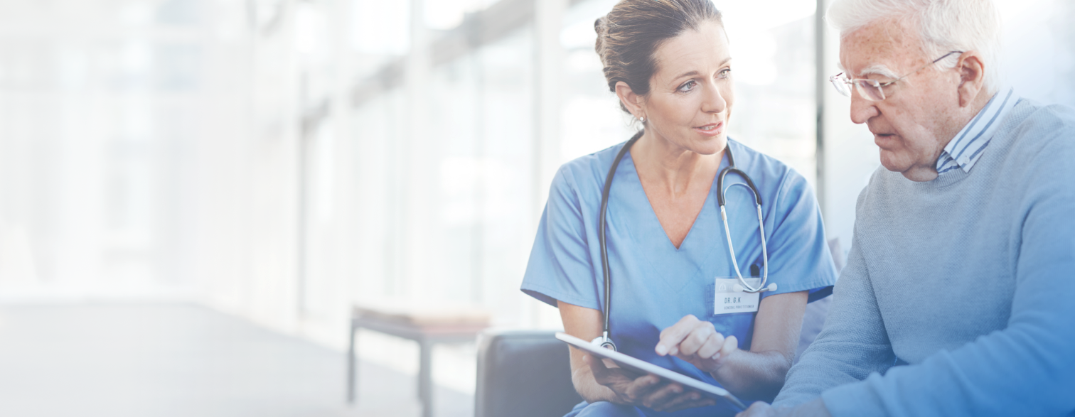 a nurse holding a tablet talking to an older man